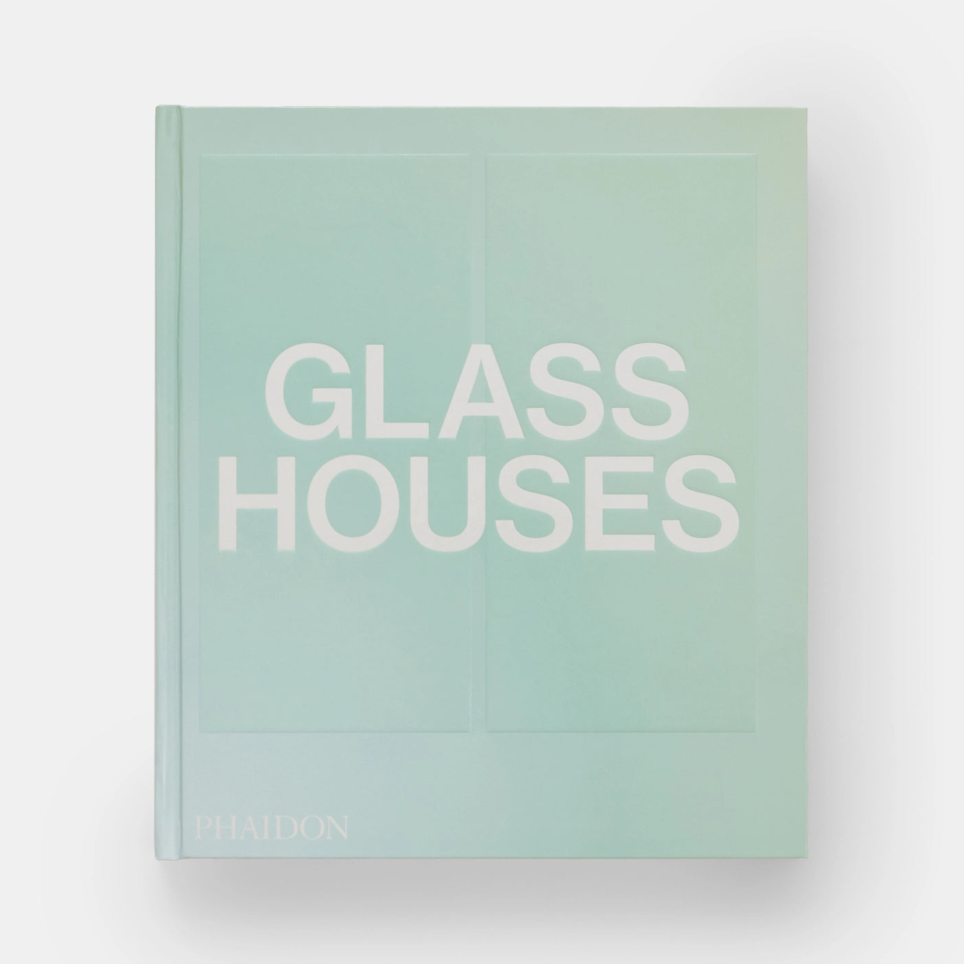 The cover of the book 'Glass Houses' by Phaidon Press, featuring a minimalist design with the title text in white on a light blue background.