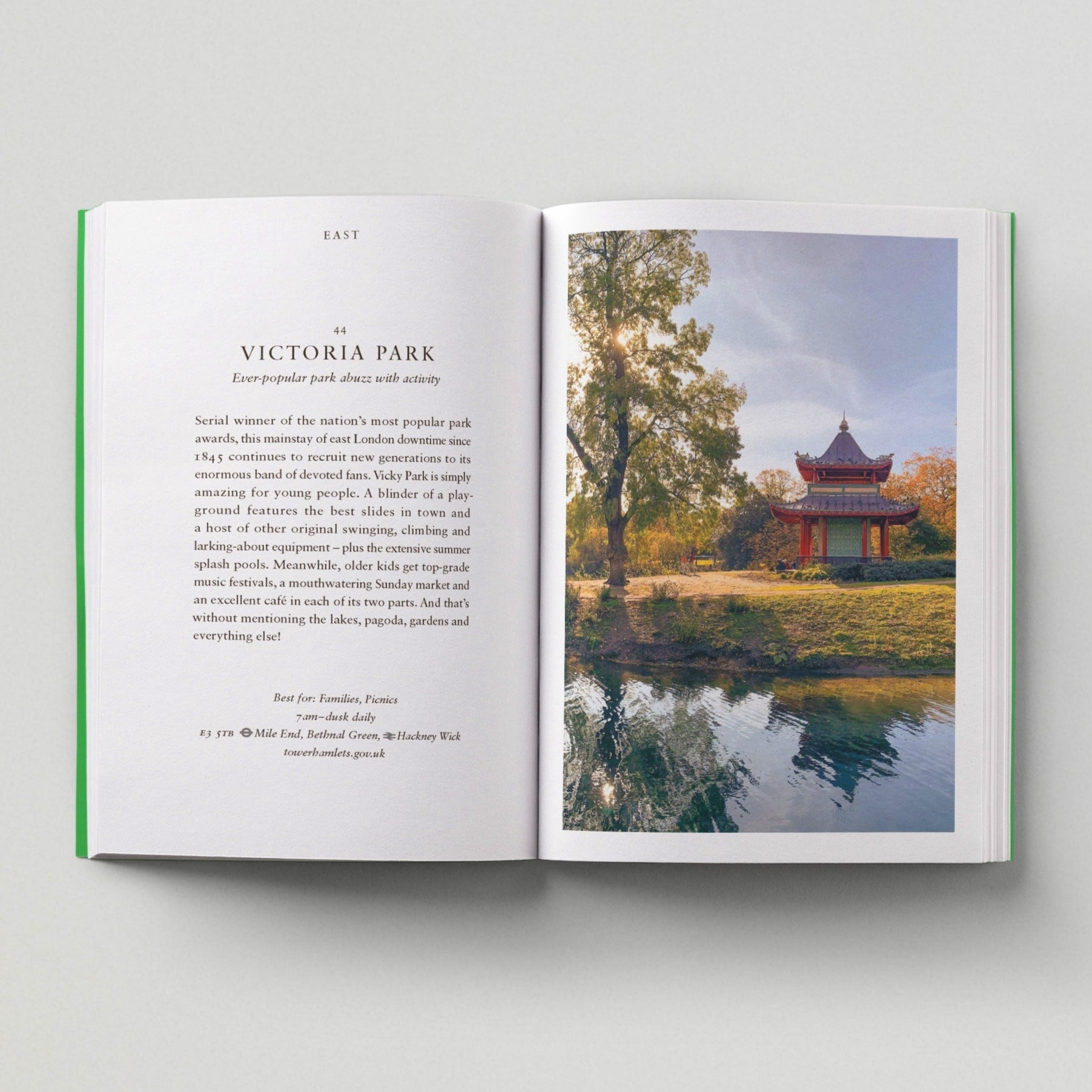 Open page of London Green Spaces book featuring a photograph of the pagoda and lake in Victoria Park.