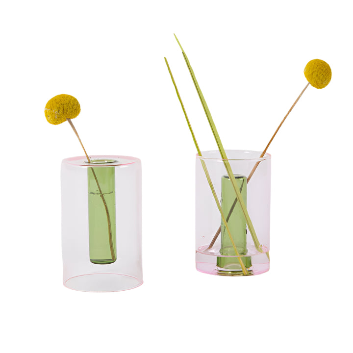 Two small pink and green reversible glass vases with dried flowers inside, displayed against a white background.