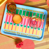 Colourful tray with decorative patterns and text on a patterned background