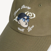 Green cap with embroidered design and text on a white background