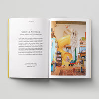 Open page of Kids London book featuring a photograph of the interior of a toy shop with toys and a yellow slide.