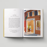 Open page of Kids London book featuring a photograph of a child in a red brick model police station.