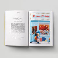 Open page of Kids London book featuring a photograph of the Round Table storefront with blue walls and door.