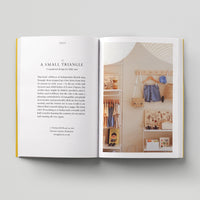Open page of Kids London book featuring a photograph of a beige shop interior with kids clothes and toys.