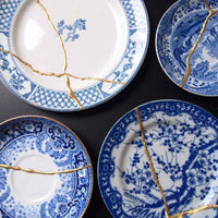 Blue decorative plates with gold kintsugi mending.