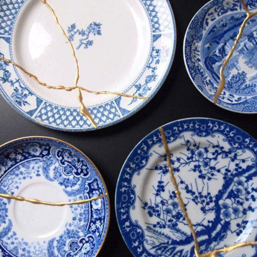 Blue decorative plates with gold kintsugi mending.
