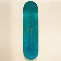 A skateboard deck with a vibrant teal and turquoise wood grain finish, displayed horizontally against a solid cream-colored background.