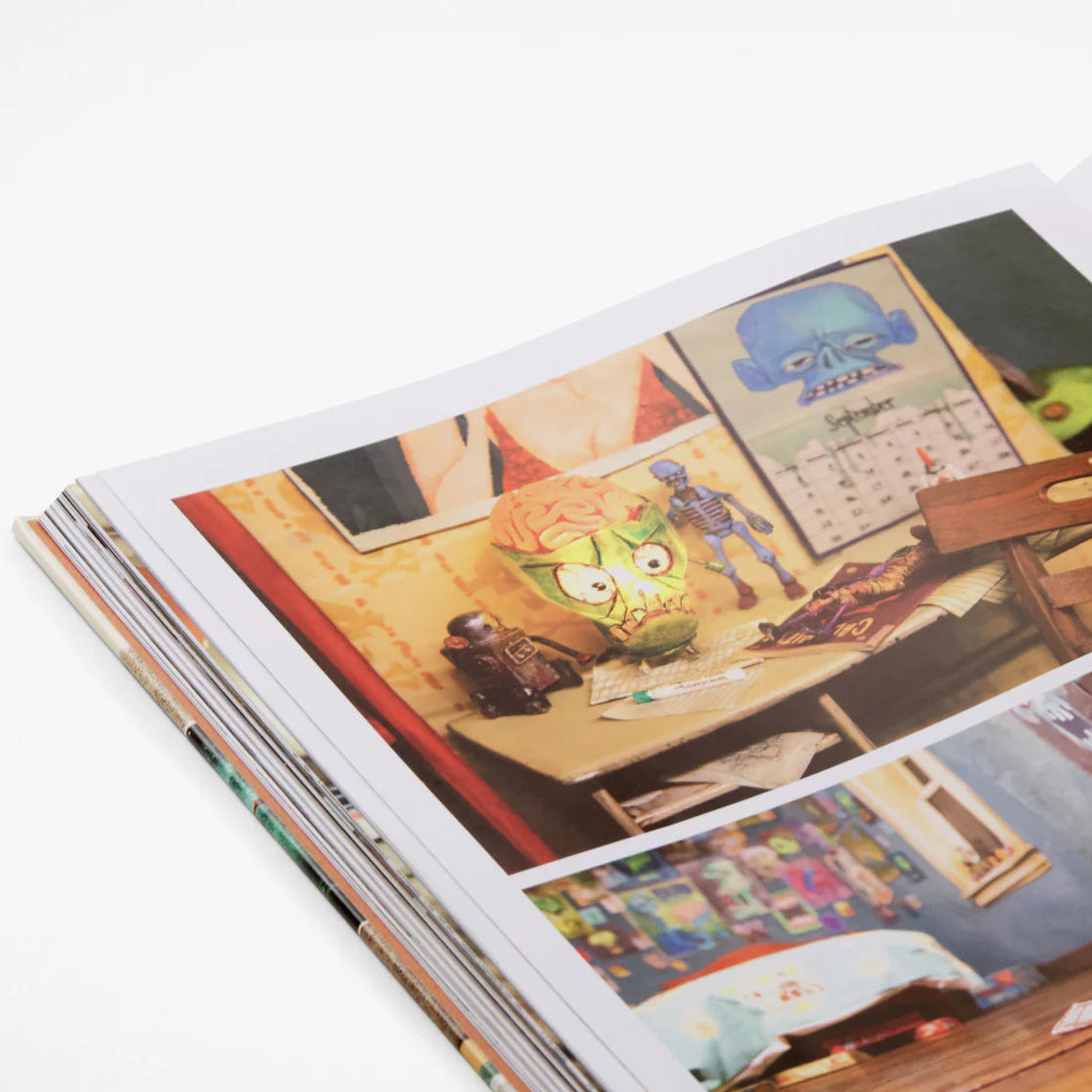 Open book showing illustrations of a room with furniture and decor.