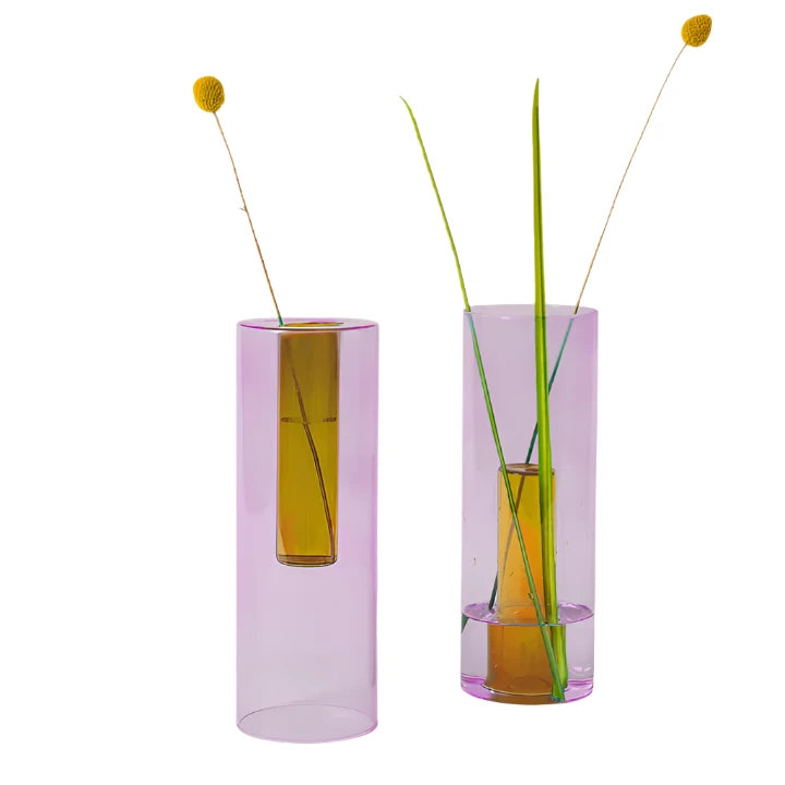 Two large reversible lilac and peach vases with dried flowers inside on a white background.