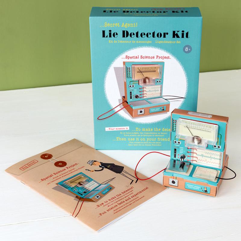 Lie Detector Kit with packaging and instructions on a white surface against a green wall.