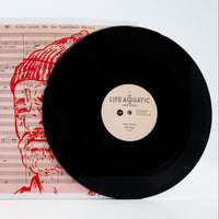 Vinyl record with 'Life Aquatic' label on a sheet of music