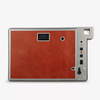 Rectangular device with brown leather-like front panel and metallic frame on a white background