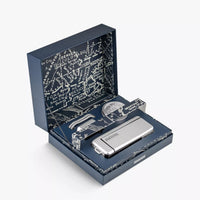 A silver camera with accessories in a decorative box with text on a white background