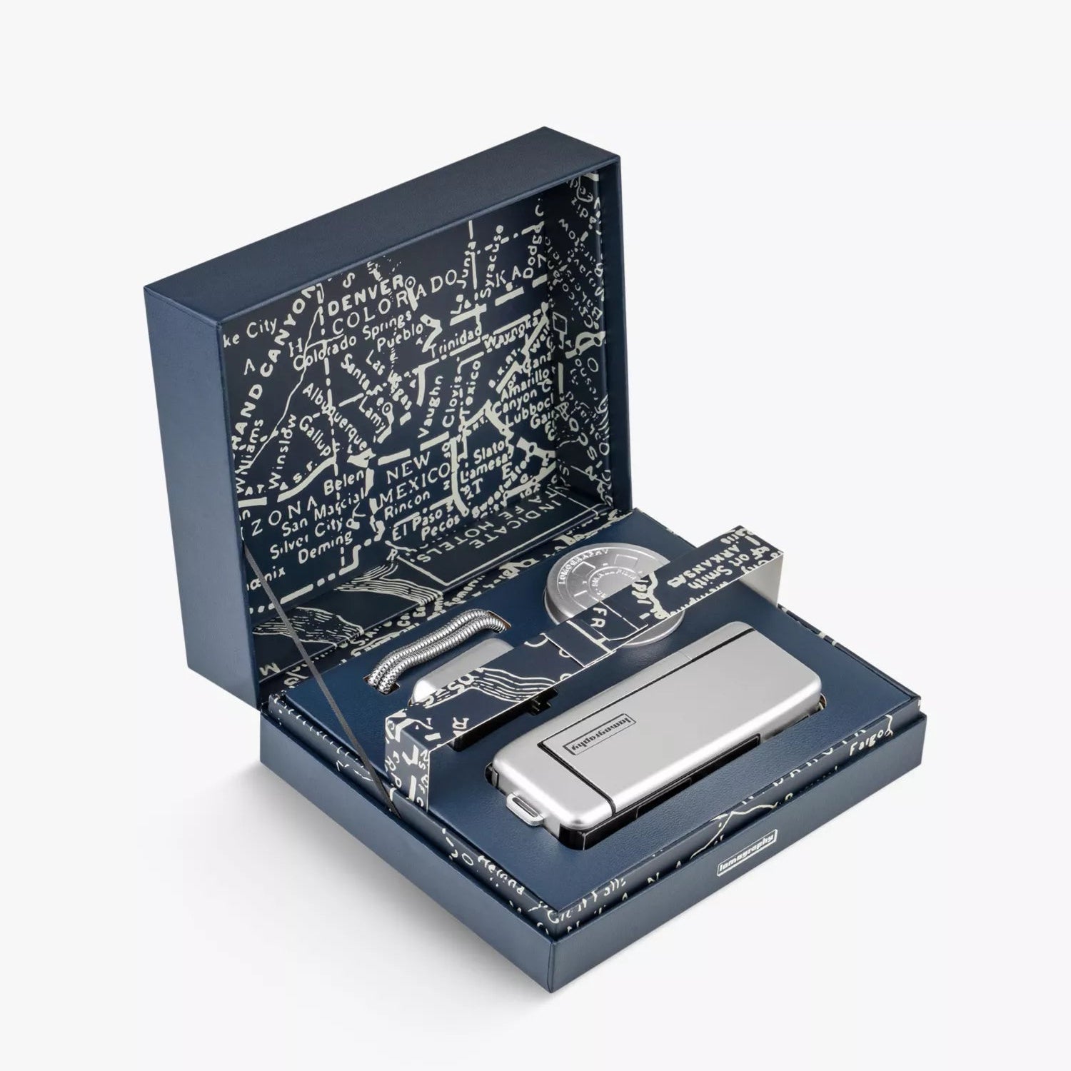 A silver camera with accessories in a decorative box with text on a white background