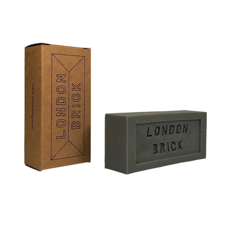 A grey rectangular block of soap with the text 'London Brick' engraved in it, next to its brown cardboard packaging.