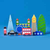 A collection of colourful wooden blocks in the shape of London landmarks and vehicles on a blue background.
