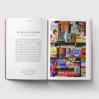 Open page of London Museums book featuring a photograph of shelves filled with colourful tins and cartons of food.