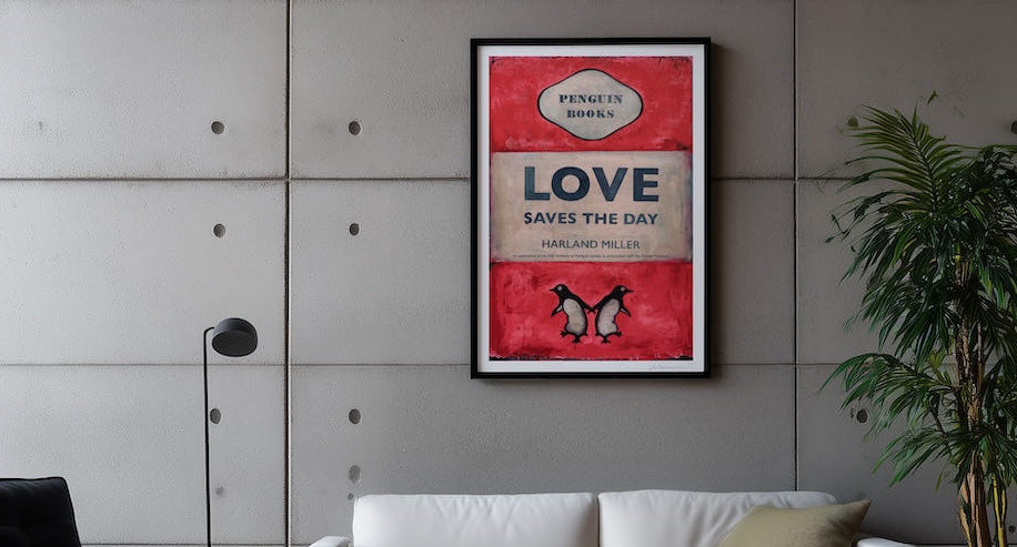 Framed poster with text and penguin illustration on a wall above a sofa.