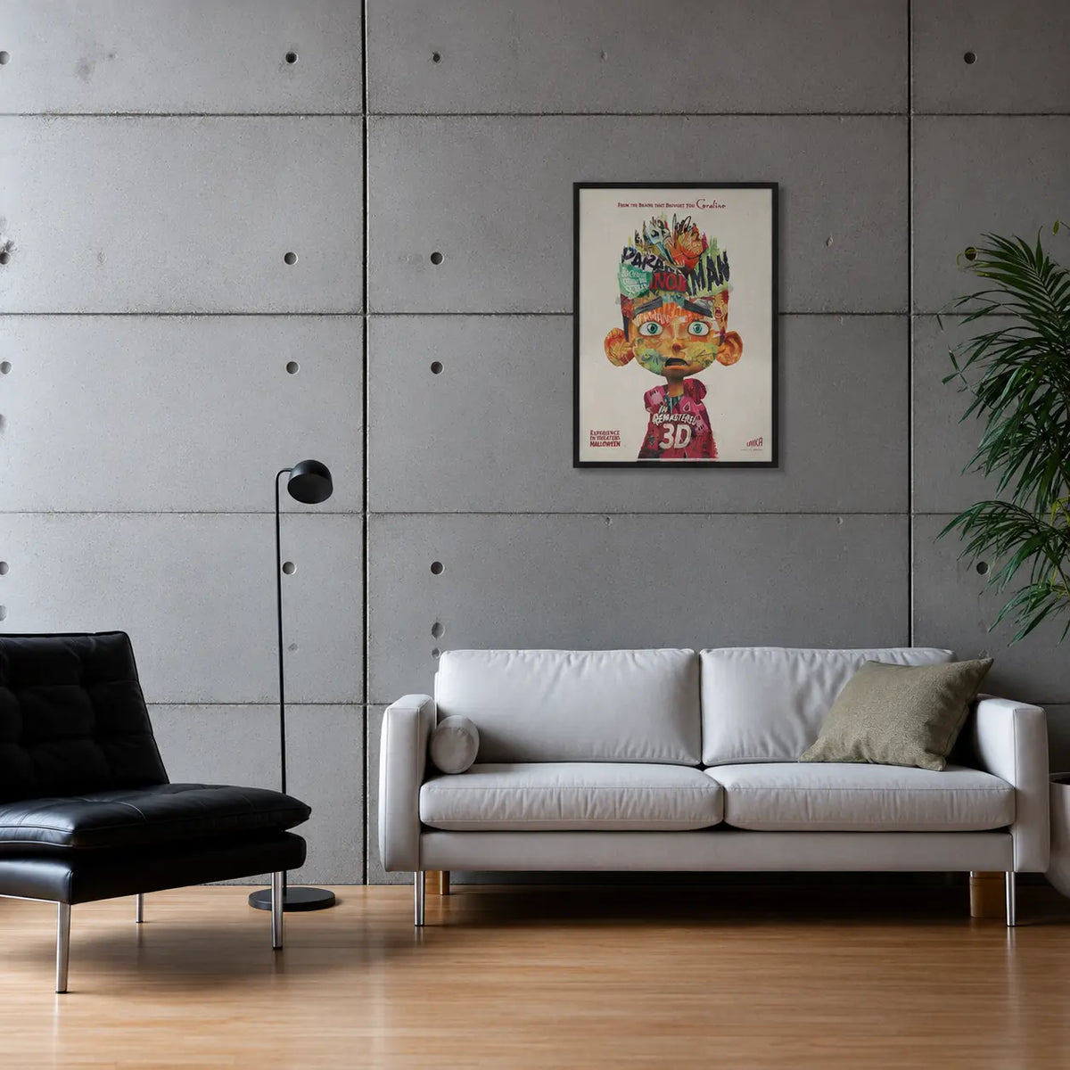 Framed poster of the film Paranorman on a grey concrete wall above a white leather sofa