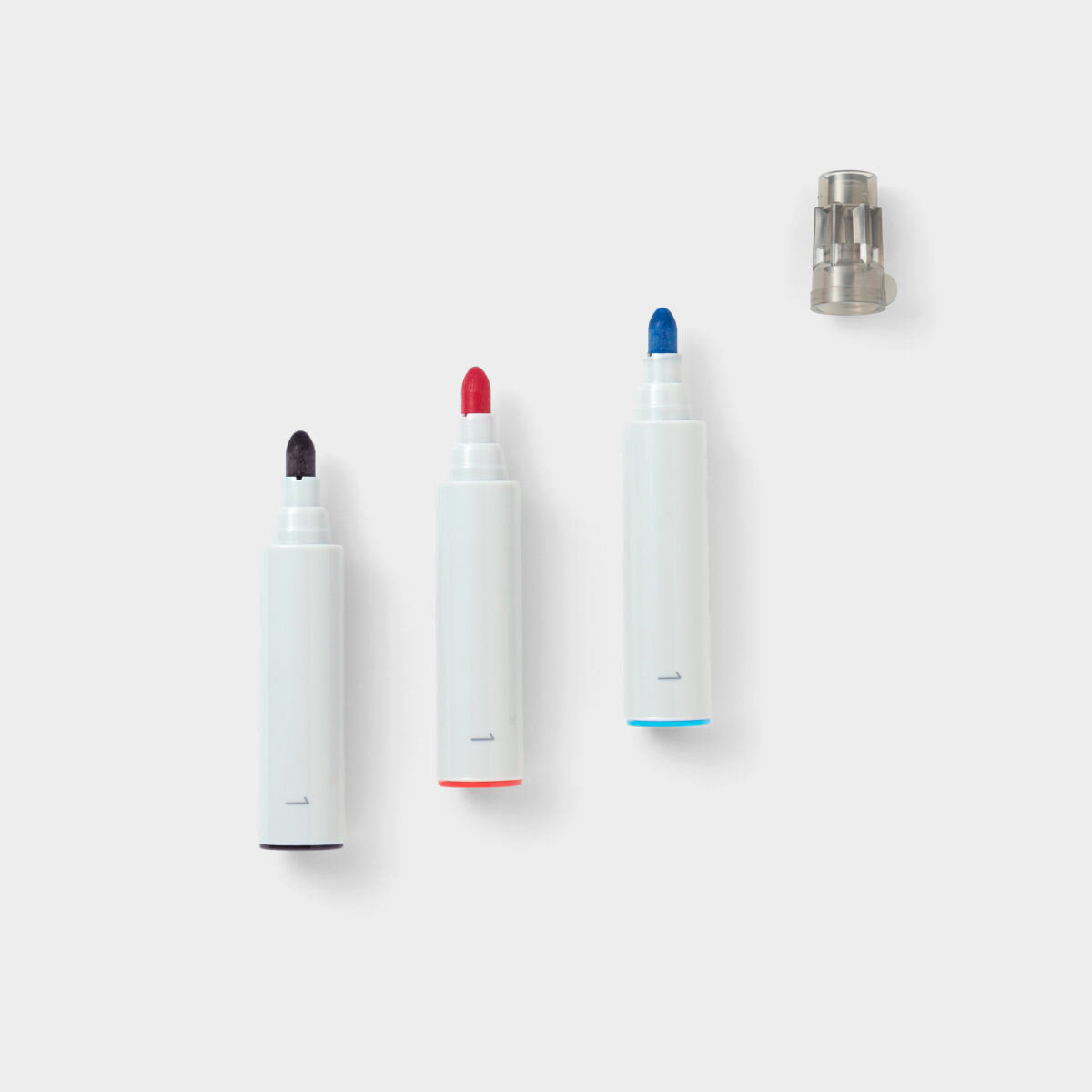 The tips of three white modular marker pens in black, red and blue.
