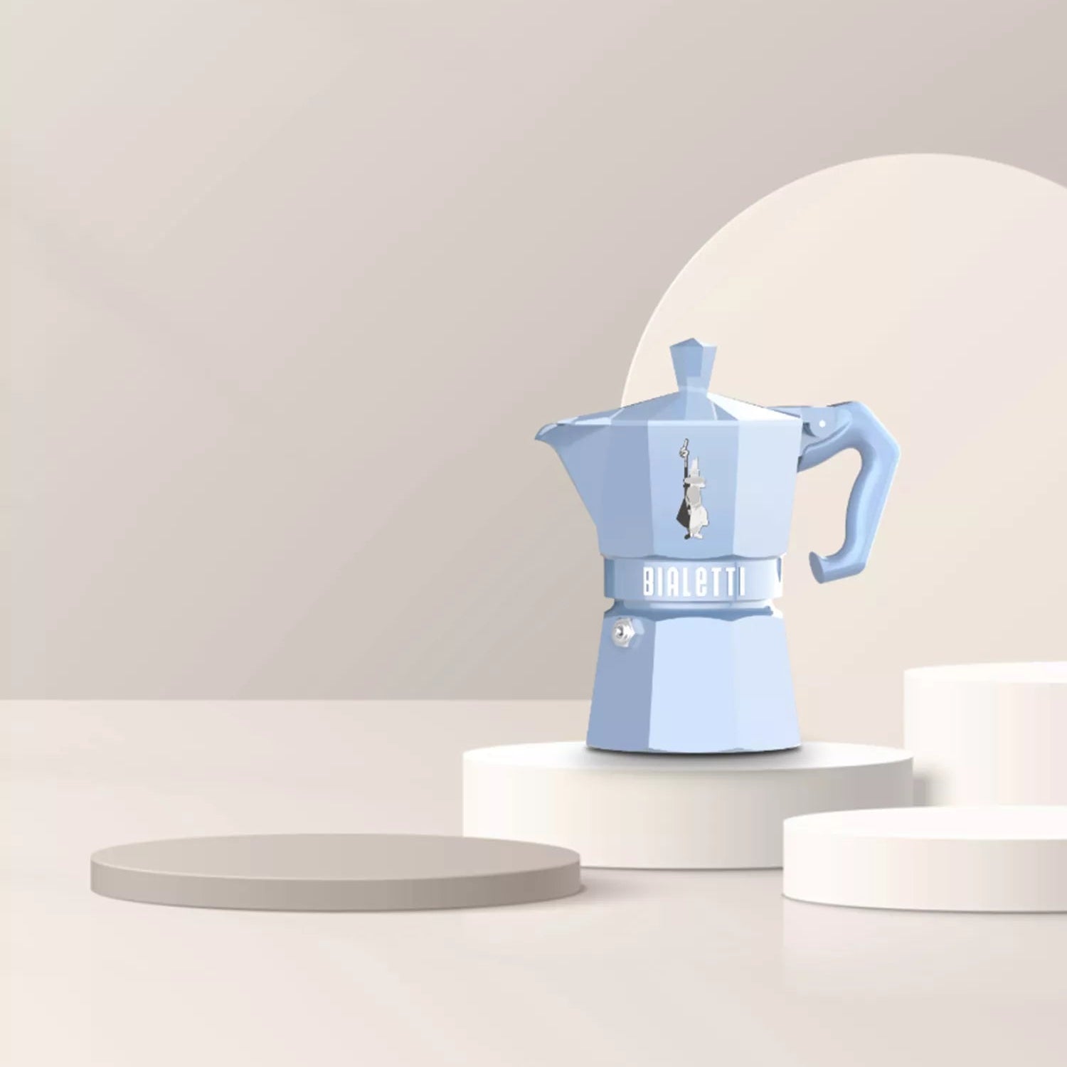 Blue espresso maker on a white pedestal against a light gray background