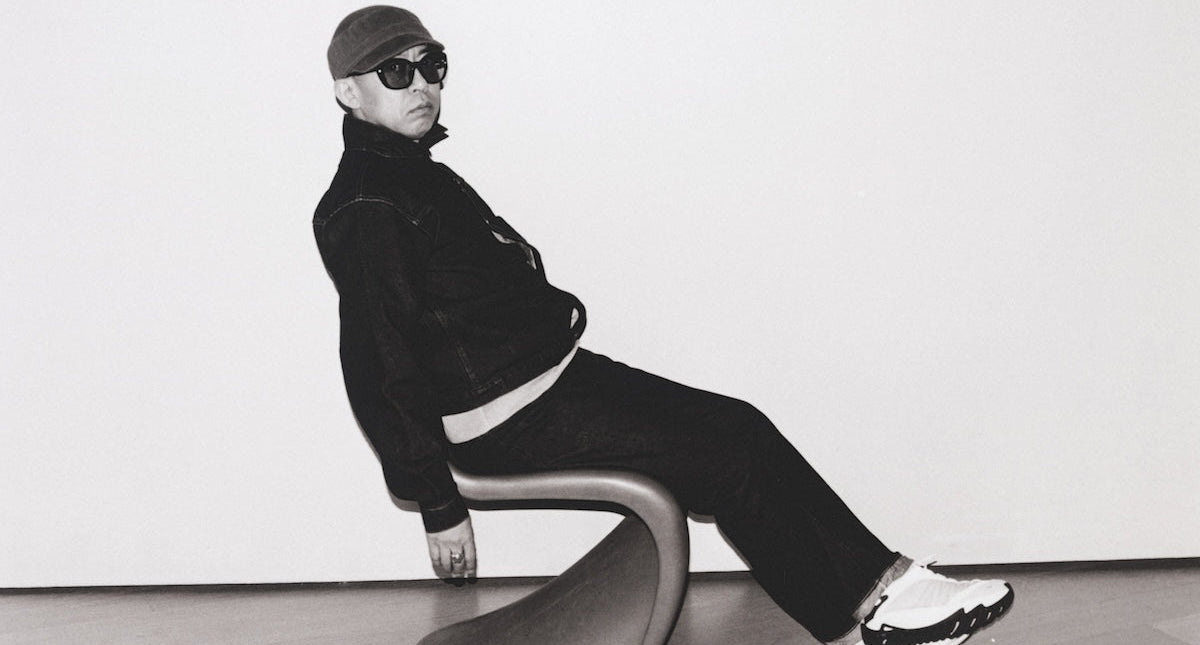 Person sitting on a modern chair against a white wall