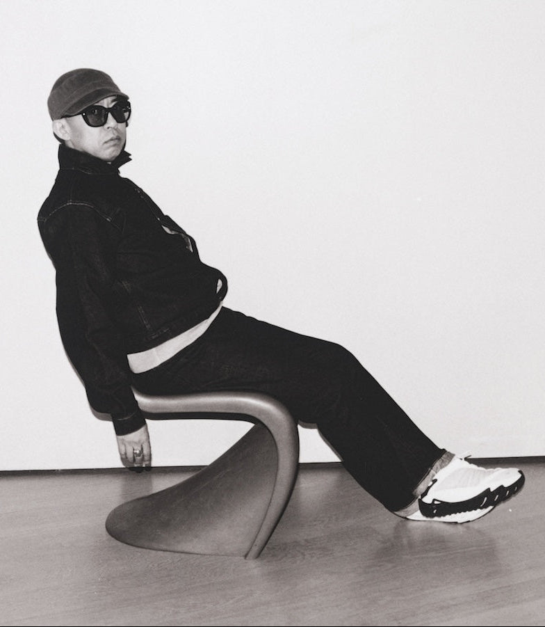 Person sitting on a modern chair against a white wall