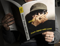 Person holding a book titled 'NIGO From Japan with Love' by NIGO.