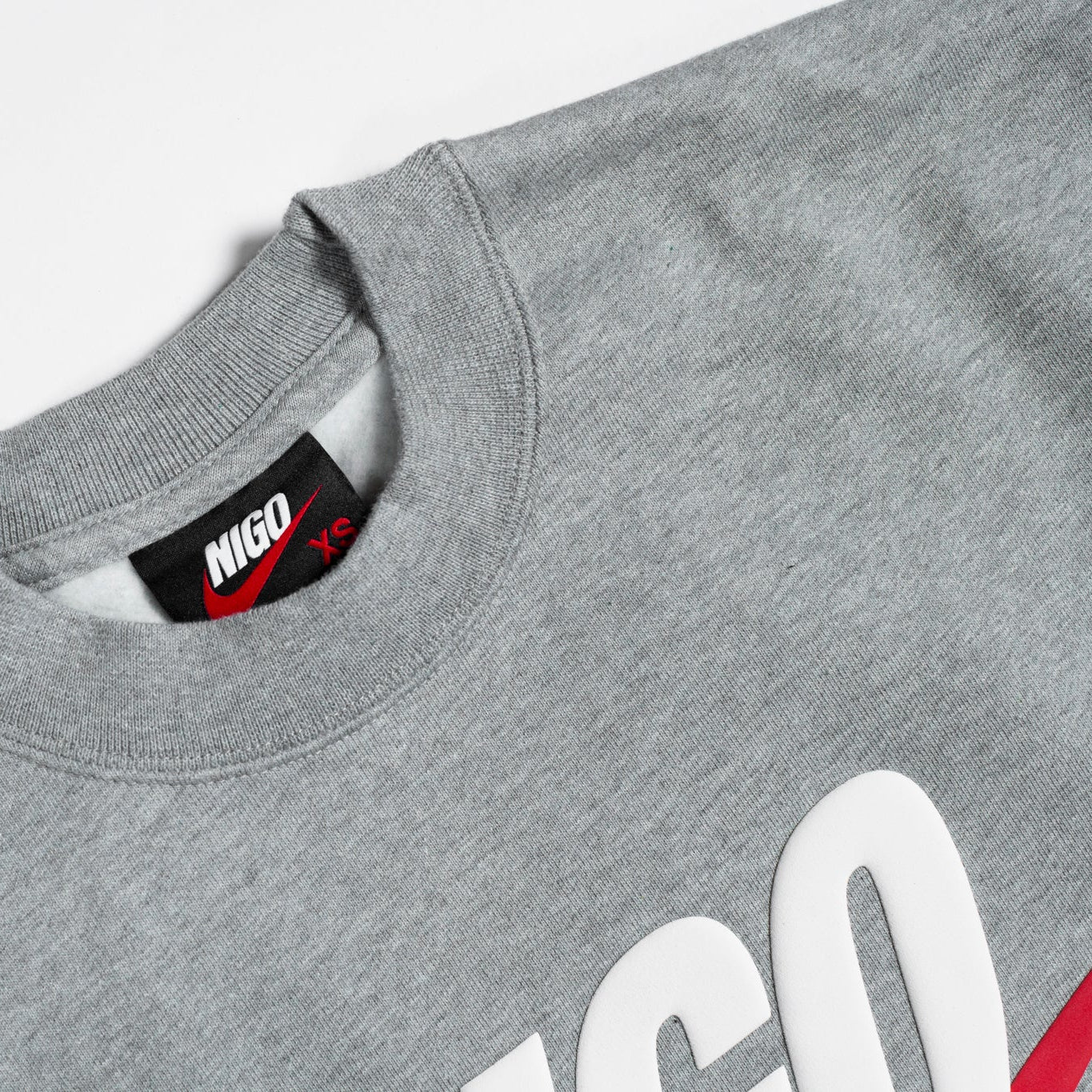 Gray sweatshirt with a brand label on a light gray background