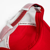 Red cap with white mesh back on a light gray background