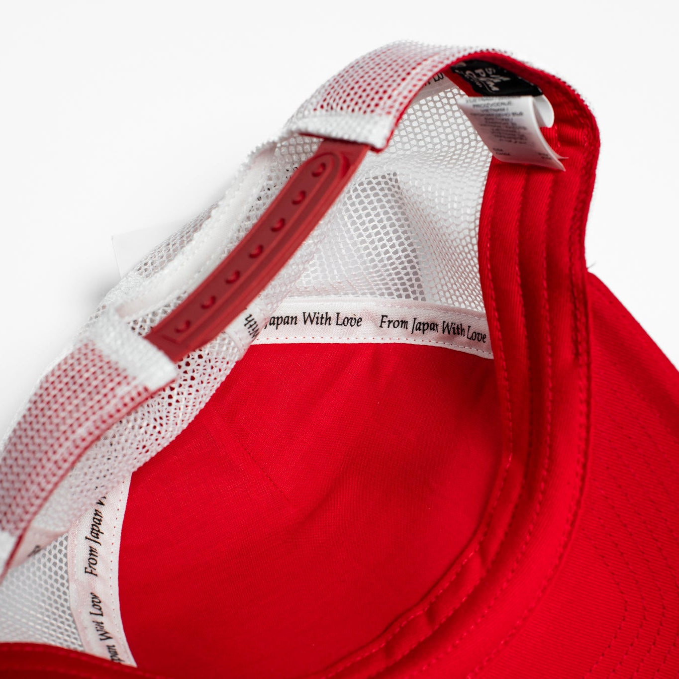 Red cap with white mesh back on a light gray background