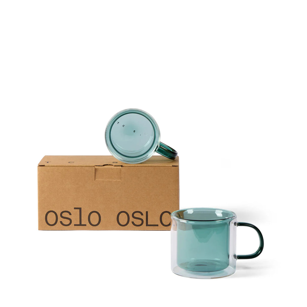 Conran shop Oslo blue/green double wall glass mug on white background, picture of 2 together next to its cardboard box that reads OSLO