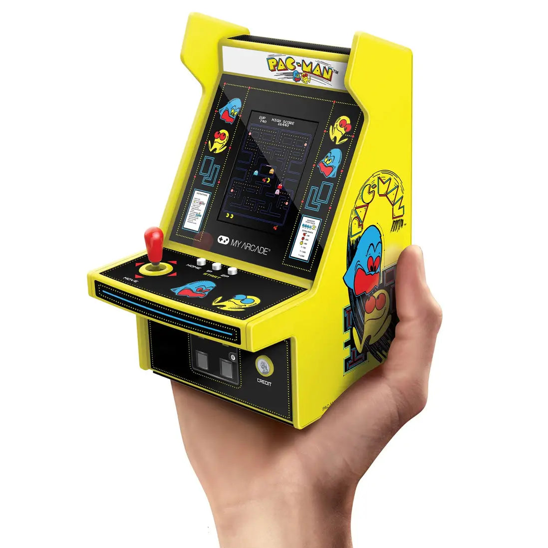 A miniature yellow and black Pac-Man arcade machine held in a person's hand against a plain white background.