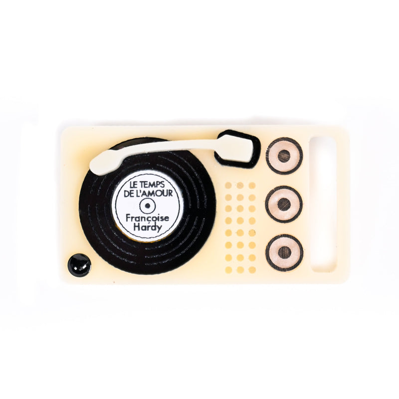 Yellow record player shaped brooch on a white background