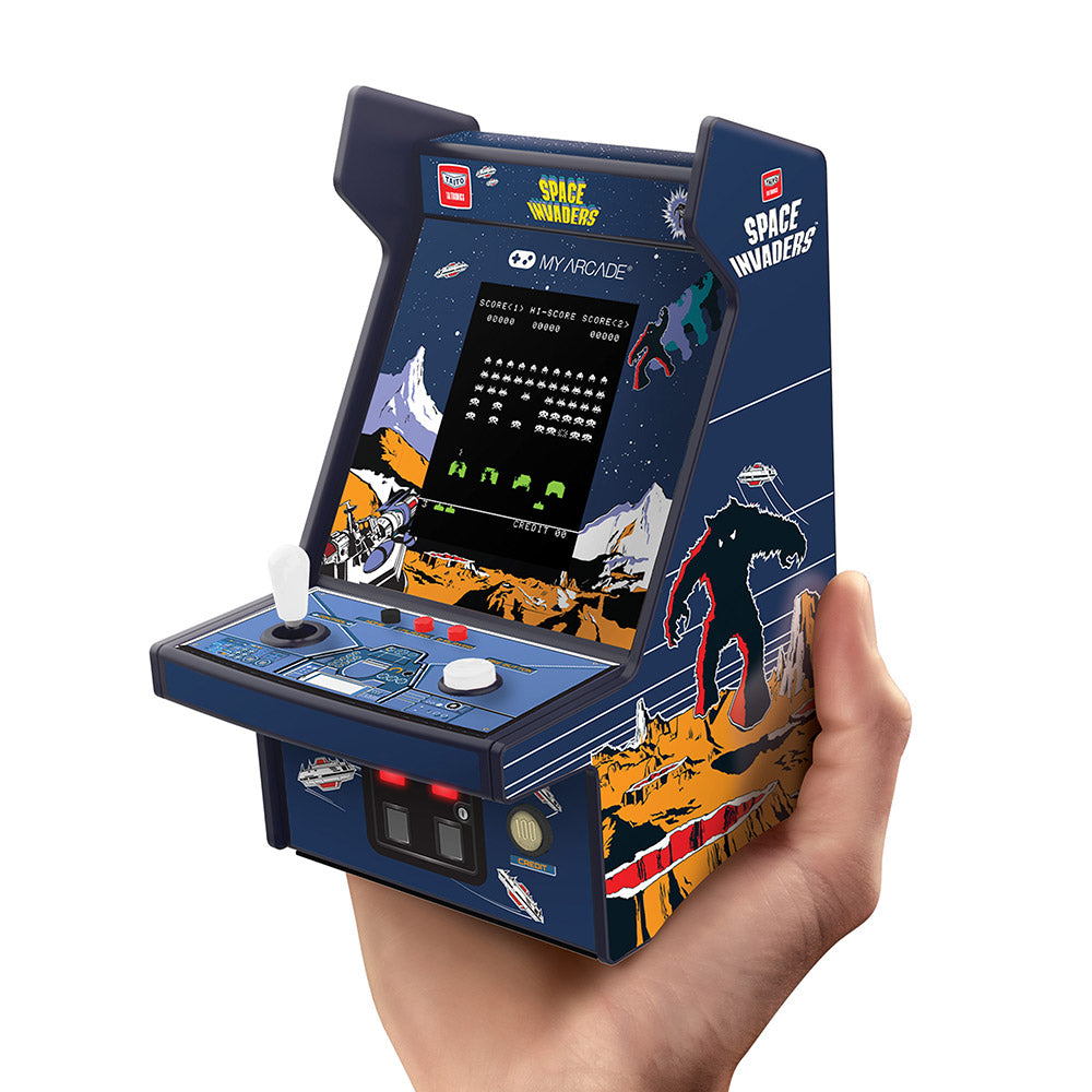 Miniature arcade game console held in a hand, featuring 'Space Invaders' design.