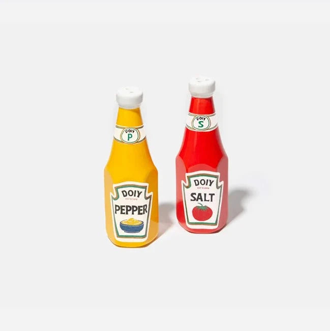 A set of two ceramic salt and pepper shakers designed to resemble ketchup and mustard bottles, one red and one yellow, with labels for salt and pepper respectively.
