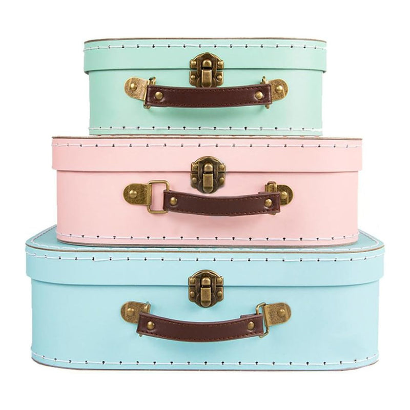 Three pastel-colored suitcases stacked on a white background