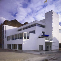 Modern building with 'Design Museum' sign against a blue sky with clouds