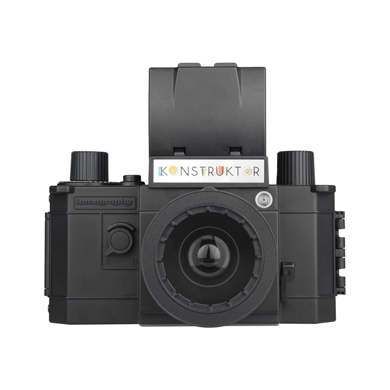 Black mechanical camera lens with 'Konstruktor' branding on a white background