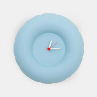 Light blue minimalist wall clock with white hands on a white background 