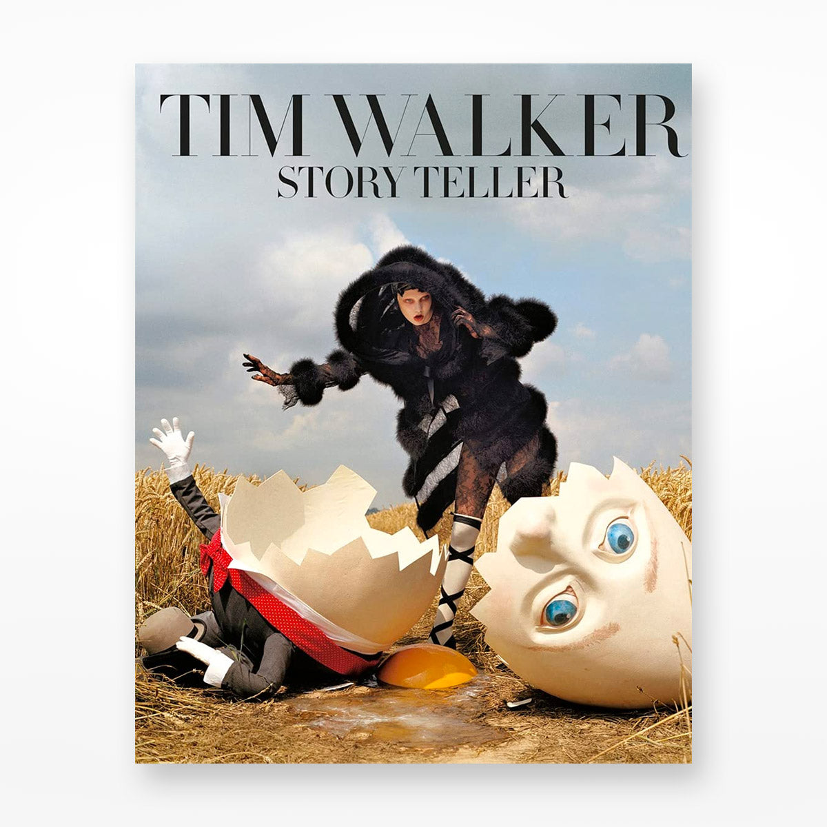 front cover of the book Story Teller By Tim Walker, cover has a broken egg face person and a female model dressed in black in a dry field on a clear sky sunny day.