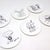 White fine china coasters with black illustrations by Tim Burton on a white background