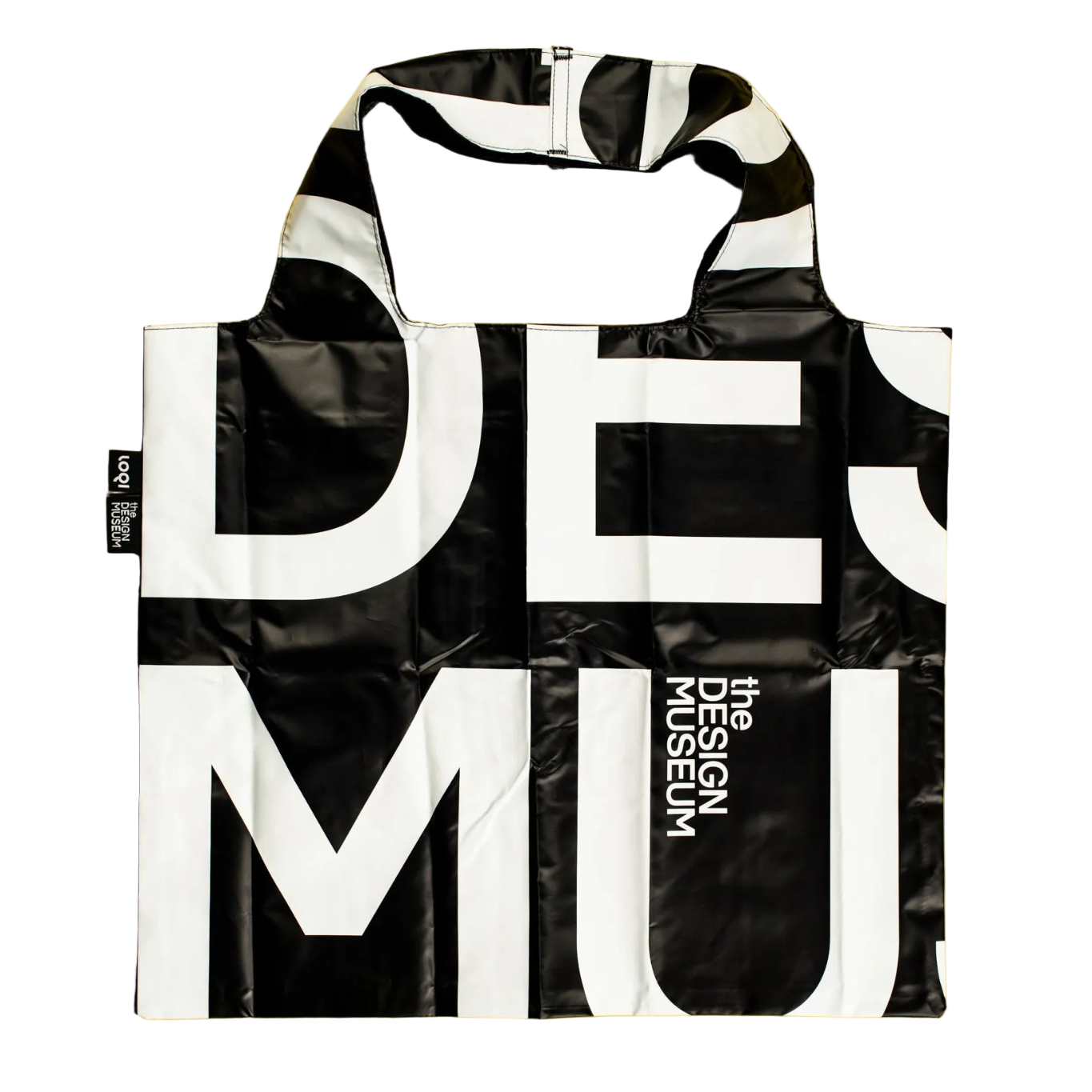 A reusable tote bag with a bold black and white graphic print featuring the words 'DESIGN MUSEUM'. The bag has a glossy, slightly reflective finish and is shown against a plain white background.