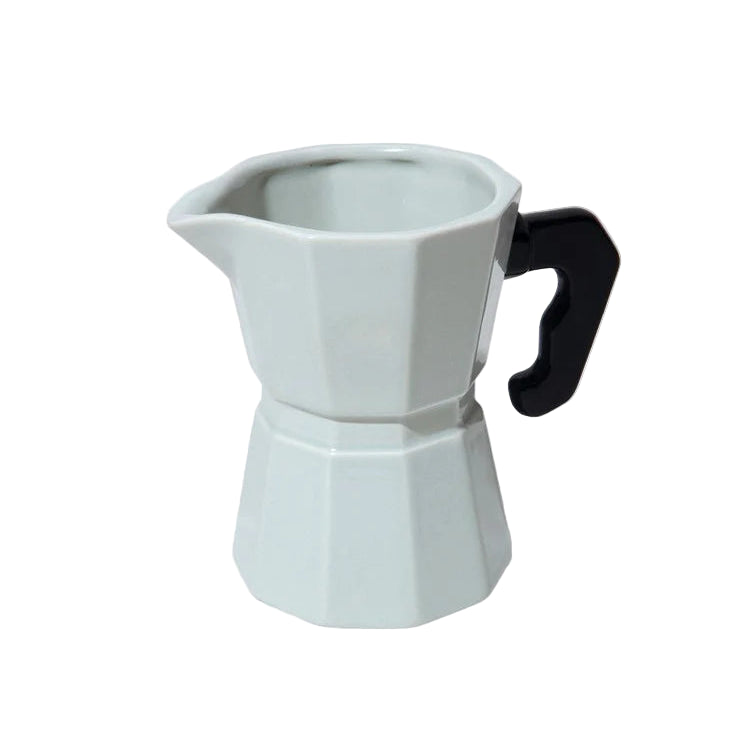 White stovetop espresso maker with a black handle on a white background