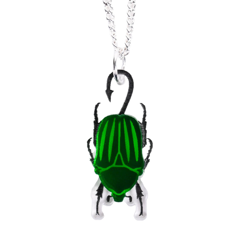 Green beetle pendant on a silver chain against a white background