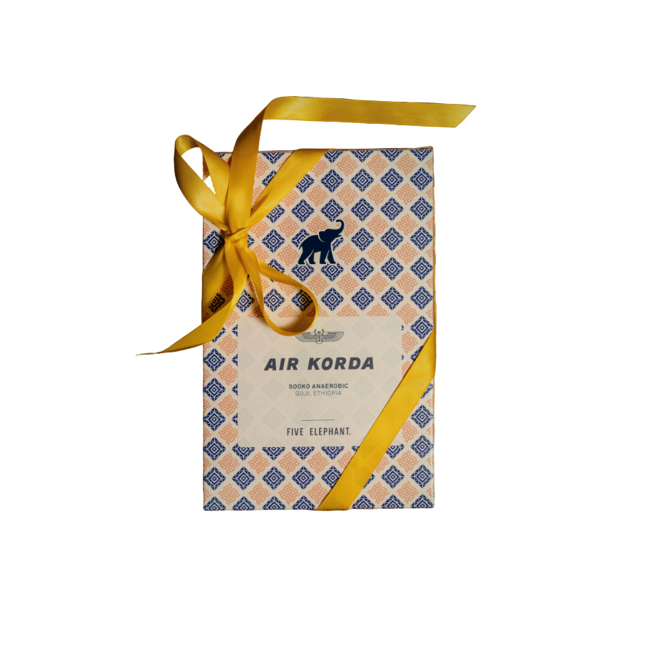 Gift box with a yellow ribbon on a textured wooden surface
