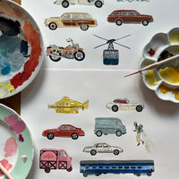 Collection of illustrated vehicles on a white surface with paint palettes and a brush.
