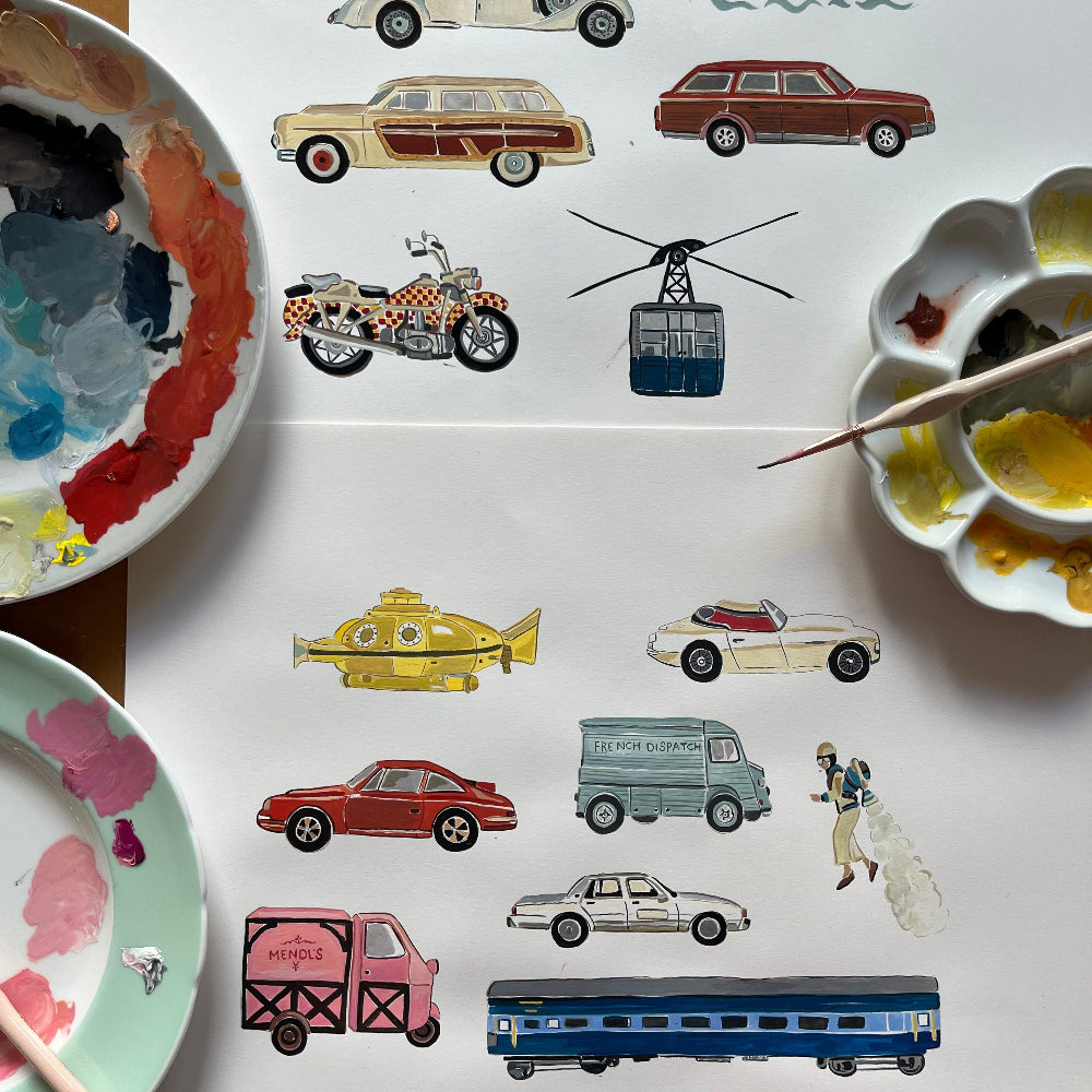 Collection of illustrated vehicles on a white surface with paint palettes and a brush.