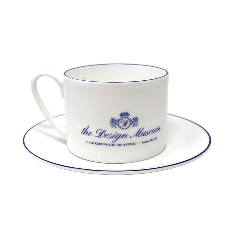 White teacup and saucer with blue text and design on a white background